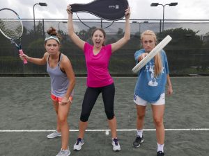 three women holding tennis rackets